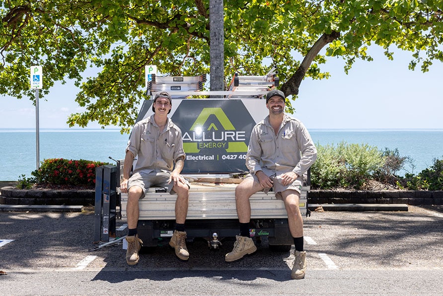 Emergency electricians from Allure Energy smiling on the back of their service truck in Cairns