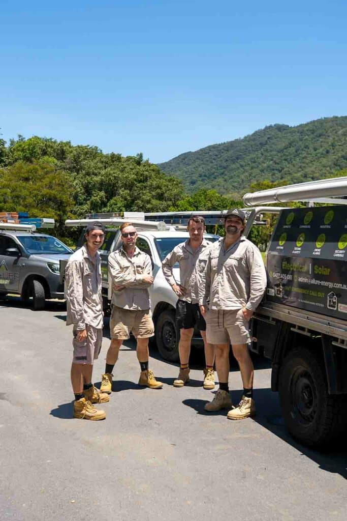 Allure Energy electricians in Cairns QLD standing beside their fully equipped service vehicles, ready for residential and commercial jobs.