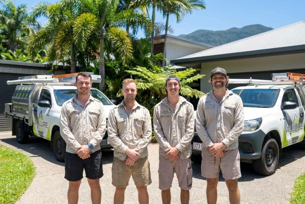 Allure Energy electricians in Cairns standing beside their work utes, ready for residential and commercial electrical jobs.