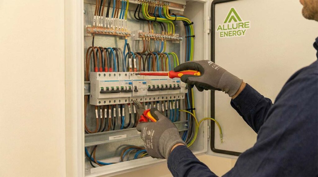 Electricians in Cairns performing electrical safety and compliance work inside a switchboard