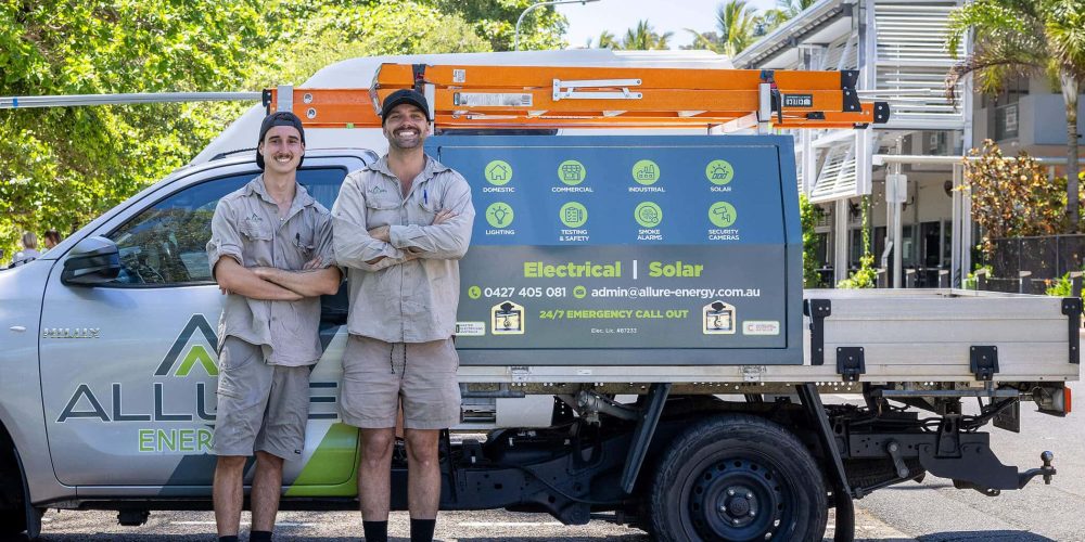 Two Allure Energy electricians standing proudly in front of their service vehicle with equipment for electrical and solar services in Cairns Queensland.