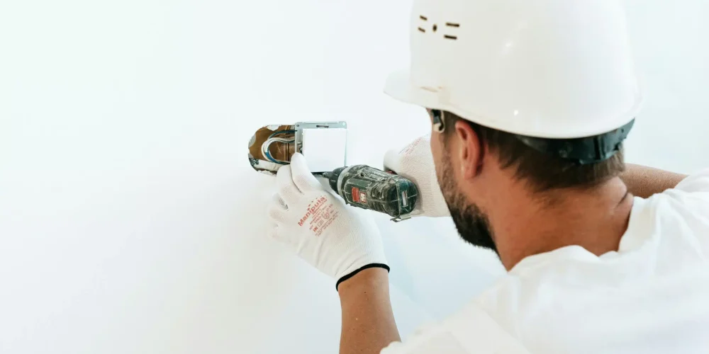 Electrician installing an eco-friendly electrical outlet, representing sustainable energy solutions